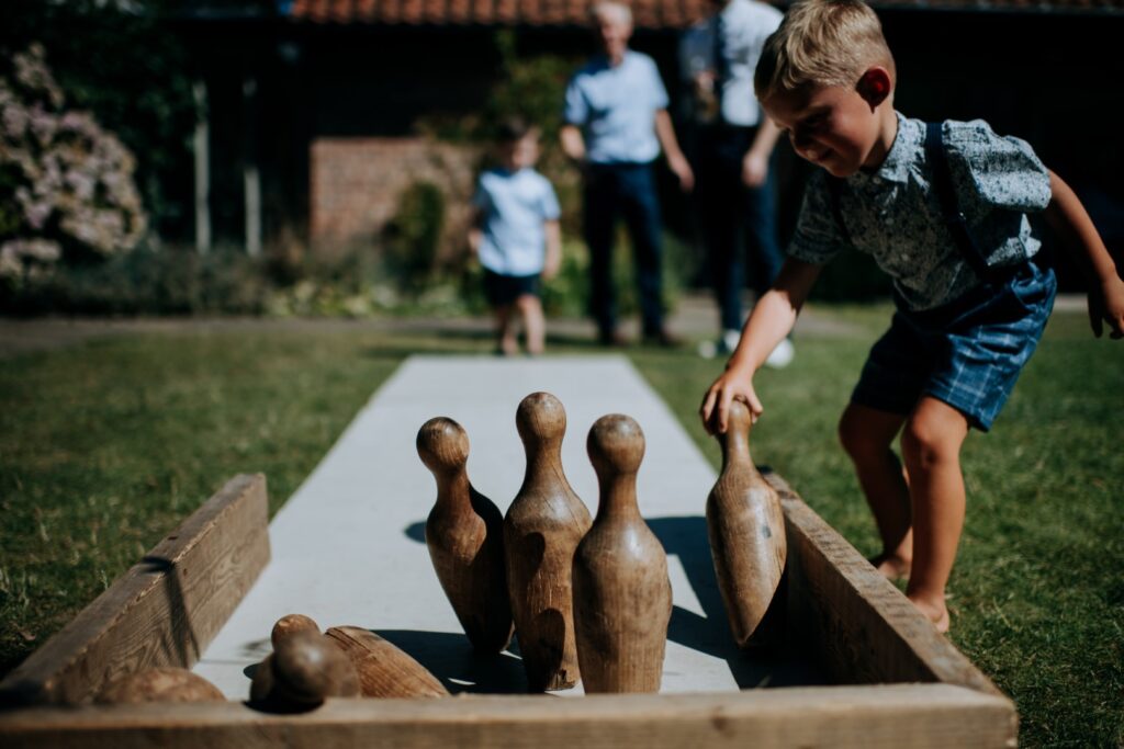 Vintage wooden skittle pins on a wooden skittle alley with children playing | garden game hire for weddings and events in Lincolnshire, Nottinghamshire and Derbyshire