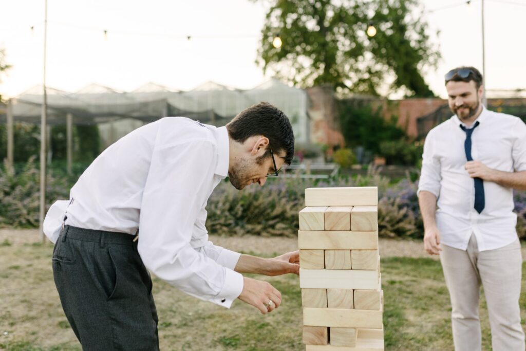 a couple of guys playing giant tumble tower | garden game for hire Lincolnshire