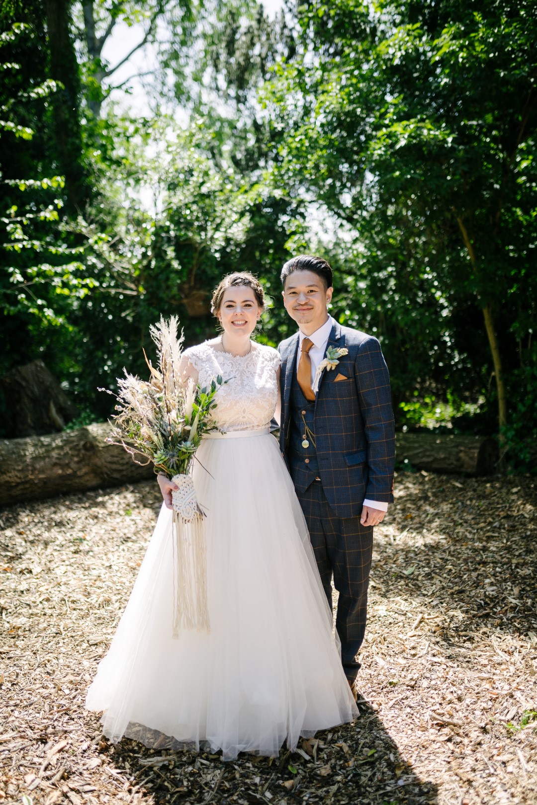 Jess and Khine on their wedding day, pictured in the woodlands at Hirst Priory. They hired garden games for their guests on their wedding day