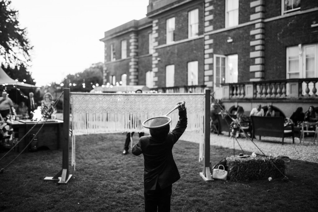 Wedding guests playing a game of badminton at Hirst Priory Wedding venue in Lincolnshire | Luxury Macrame Badminton garden game hire in Lincolnshire, Nottinghamshire and Derbyshire