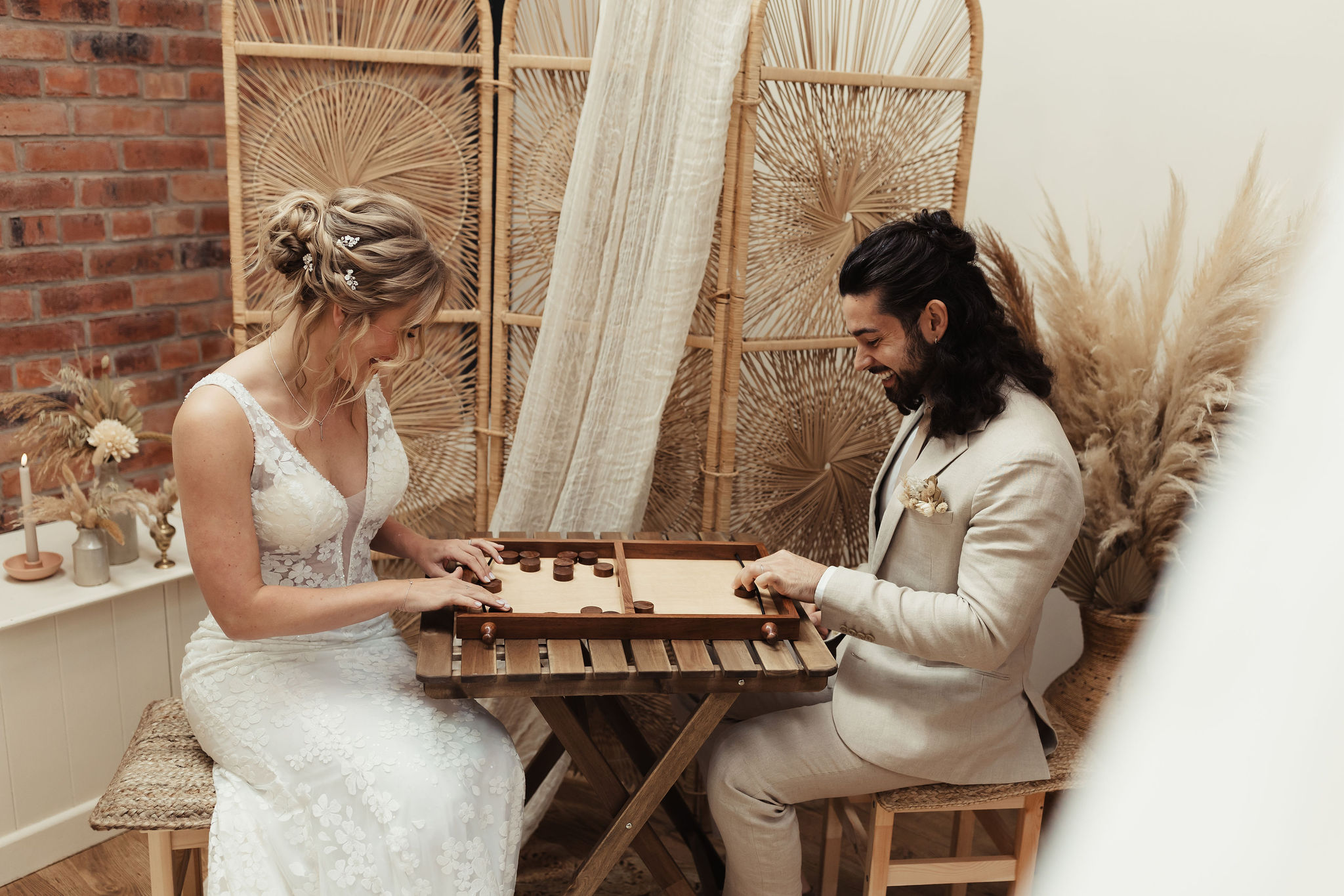 wedding couple playing a game of pucket with boho styling details around it | Pucket luxury indoor games available to hire for weddings and events