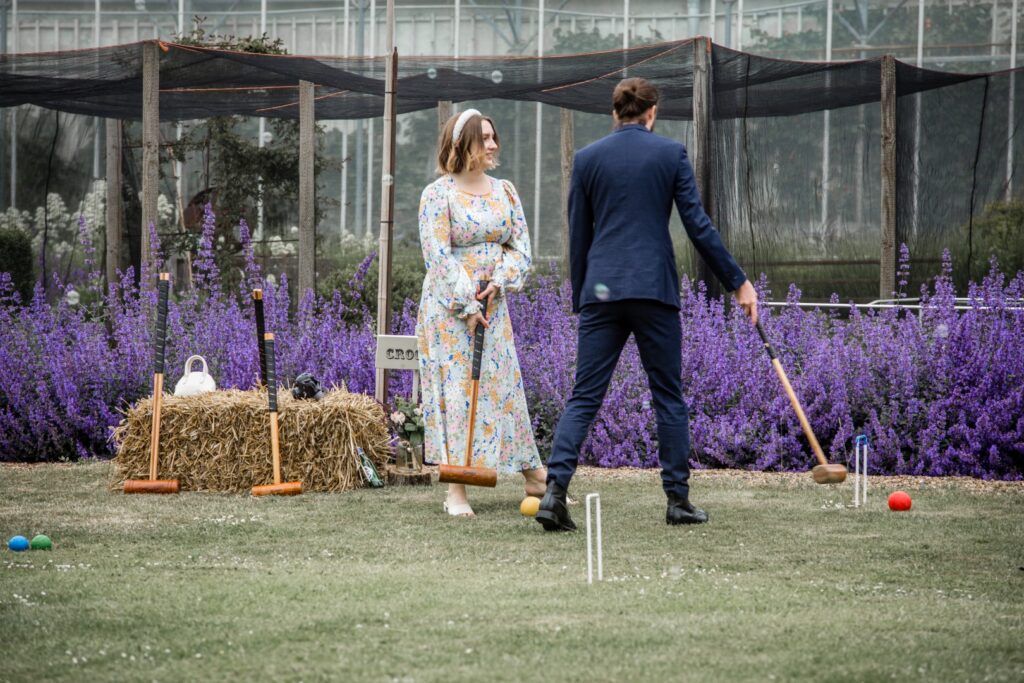Wedding guests laying croquet on the lawn. One of the best wedding garden games