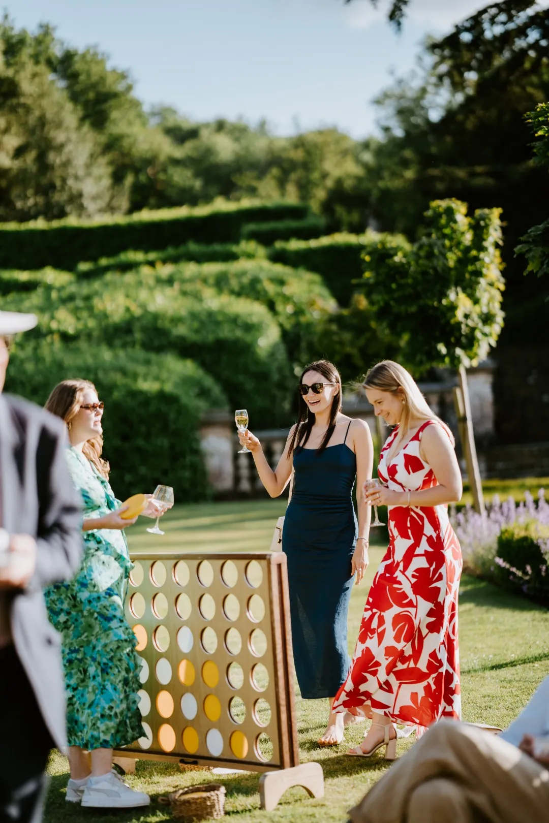 Wedding guests drinking, chatting and playing a game of connect 4. A relaxed, informal and fun wedding drinks reception