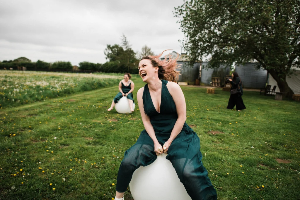 Wedding guests having lots of fun on space hoppers. Wedding garden games create a fun, relaxed wedding
