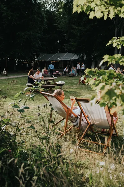 Guests relaxing in Deckchairs hired for a wedding. A relaxed informal wedding vibe