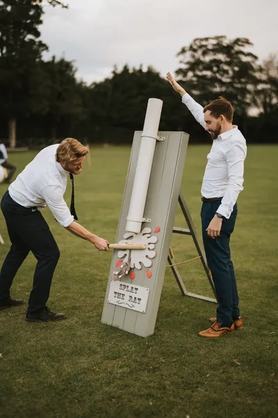 Wedding guests playing a splat the rat game. The perfect accompaniment for a relaxed, informal wedding, full of fun.