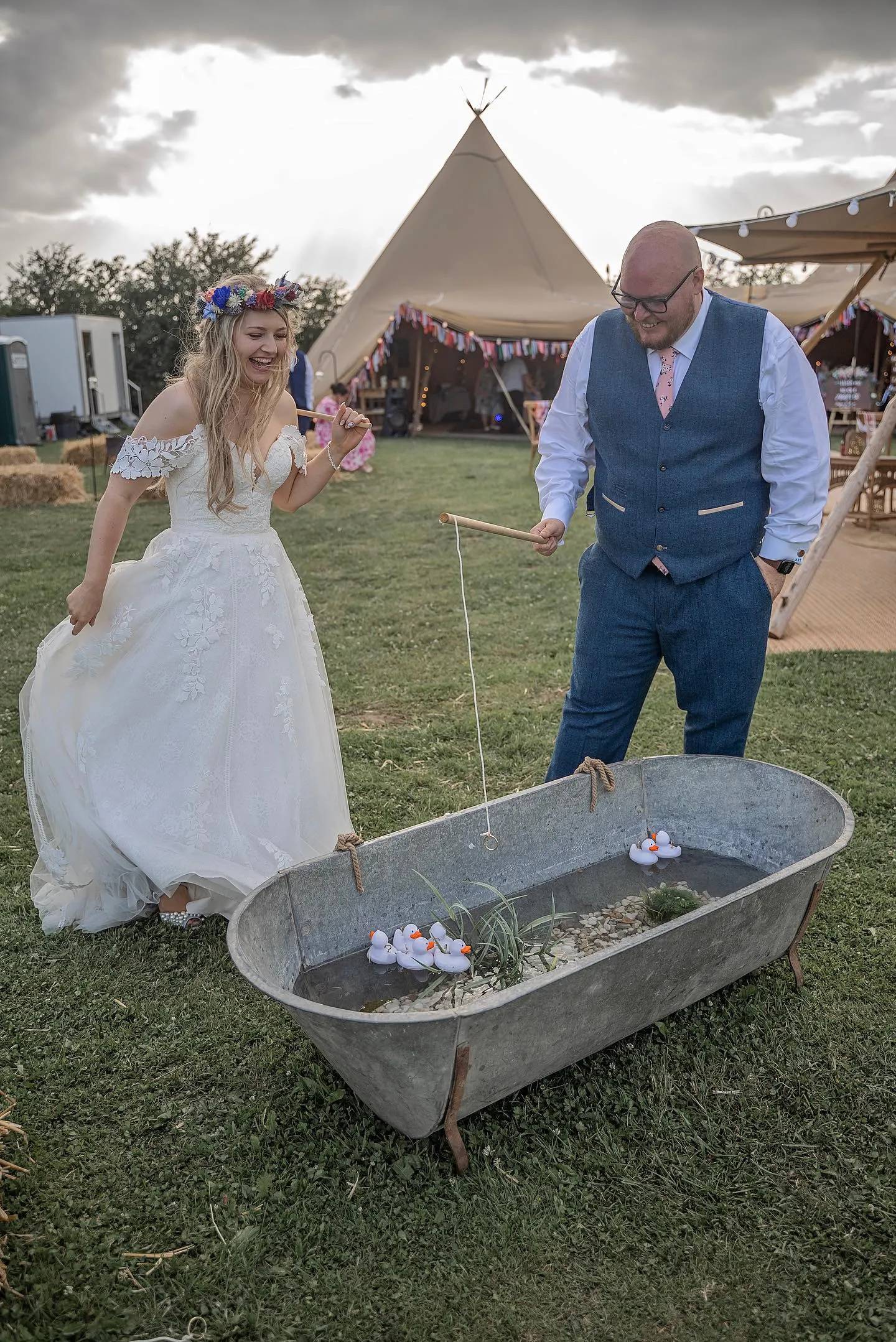 A bride and groom playing a game of Hook a Duck. A traditional funfair garden game great for fun weddings