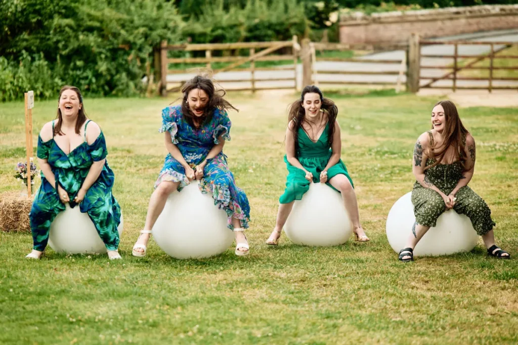 Wedding guests having a space hopper race. Plenty of inner child fun