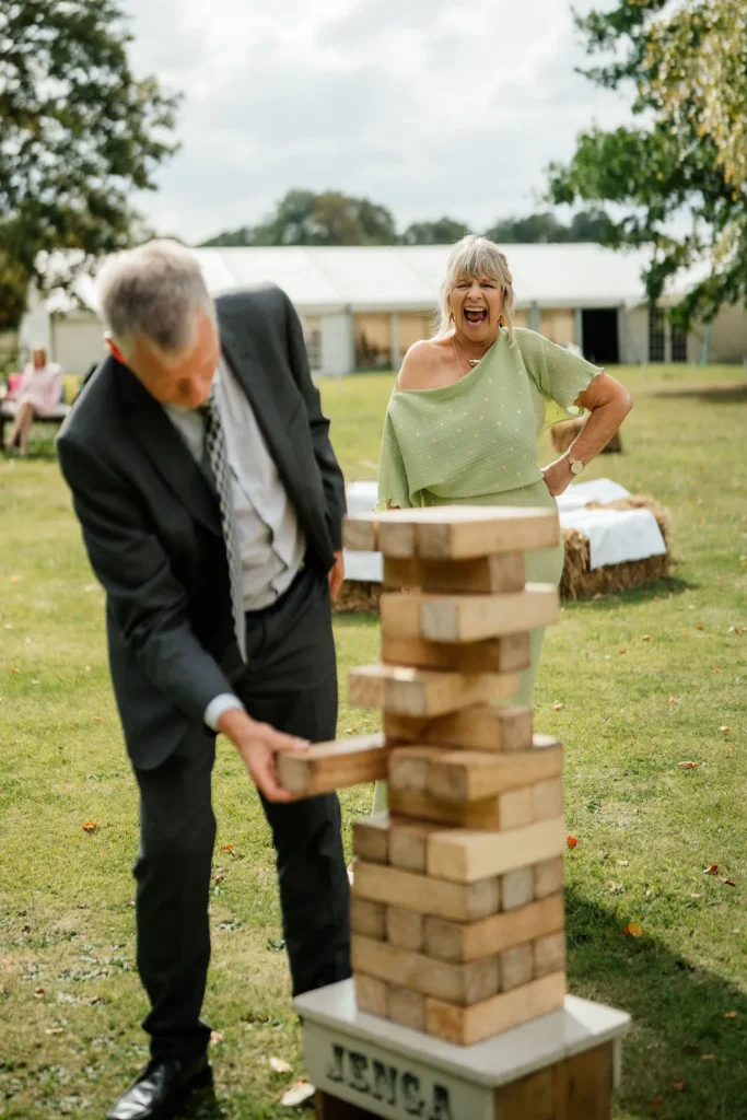 Wedding guests playing a game of Giant Jenga at this relaxed informal wedding drinks reception